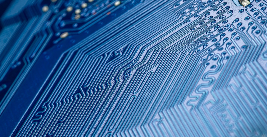 Macro photo of electrical paths on blue circuit board, selective focus.